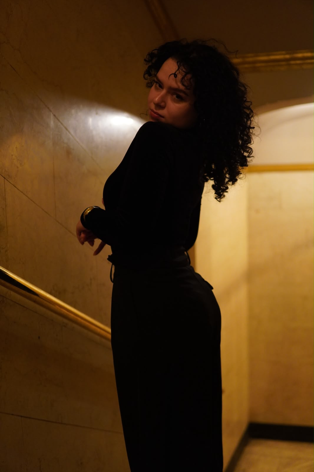 Portrait in a marble stairwell, gold light